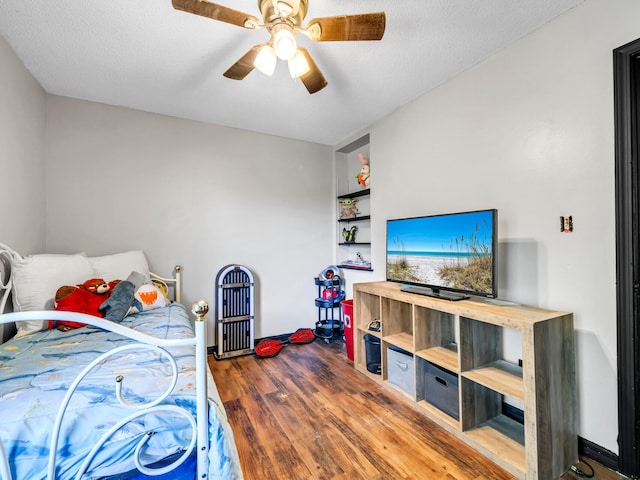 bedroom with ceiling fan, a textured ceiling, and wood-type flooring