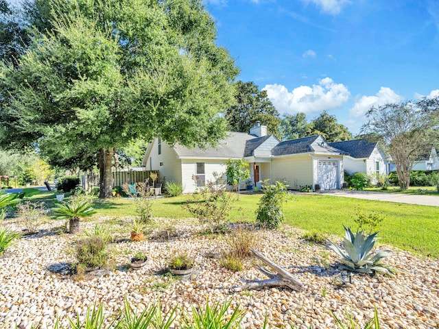 view of front facade featuring a garage, a chimney, aphalt driveway, and a front yard