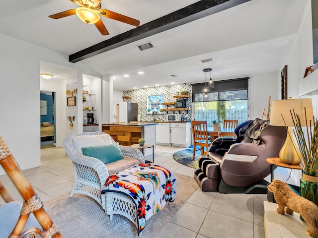 living room with light tile patterned flooring, beamed ceiling, and ceiling fan