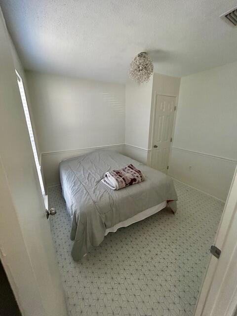 bedroom featuring a textured ceiling and visible vents