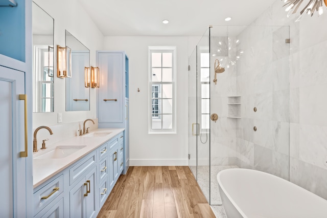 bathroom featuring wood-type flooring, vanity, shower with separate bathtub, and a chandelier