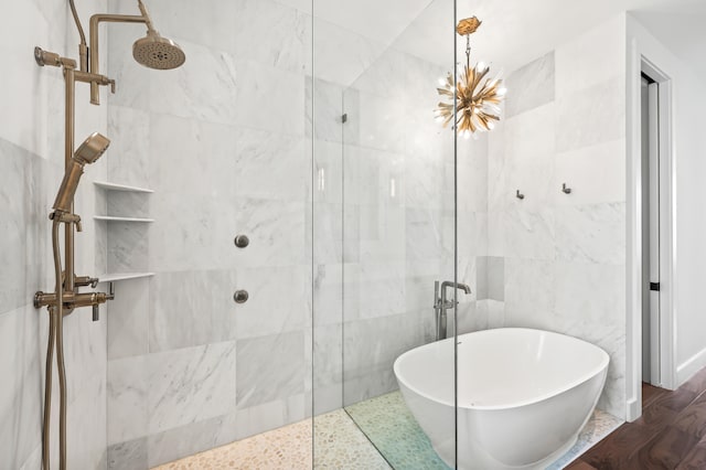 bathroom with hardwood / wood-style floors, tile walls, separate shower and tub, and a chandelier