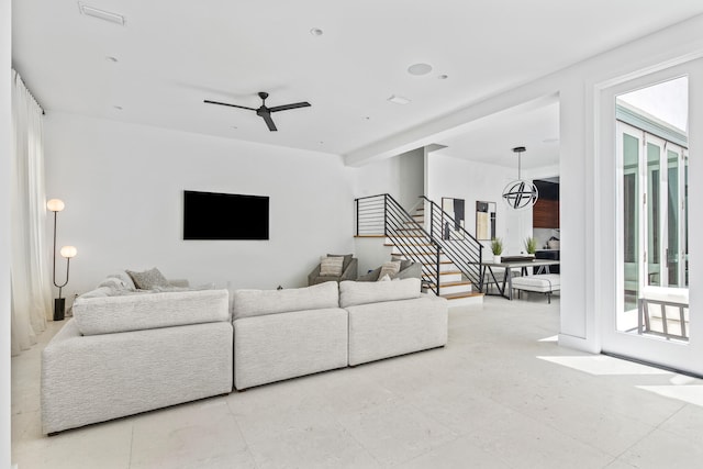 living room featuring ceiling fan with notable chandelier