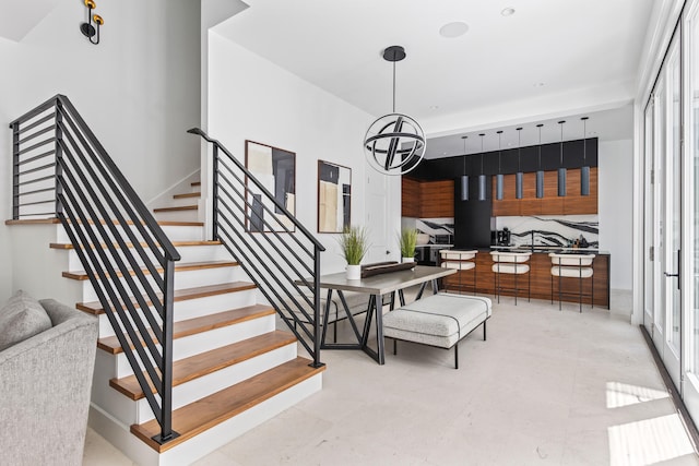 staircase with a healthy amount of sunlight and an inviting chandelier