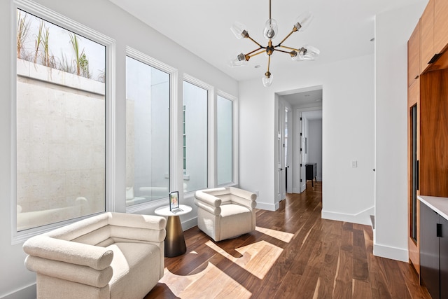 sitting room featuring a healthy amount of sunlight, dark hardwood / wood-style floors, and a notable chandelier