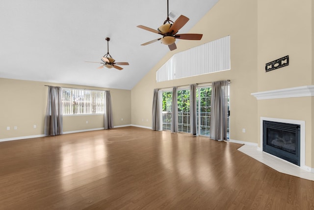 unfurnished living room featuring ceiling fan, high vaulted ceiling, and light wood-type flooring