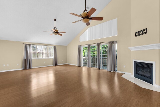 880 Brande Ct, Shalimar, FL 32579 - unfurnished living room with ceiling fan, high vaulted ceiling, healthy amount of natural light, wood finished floors, and a fireplace with flush hearth