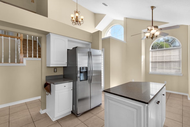 kitchen with light tile patterned floors, white cabinetry, a center island, stainless steel fridge with ice dispenser, and ceiling fan with notable chandelier