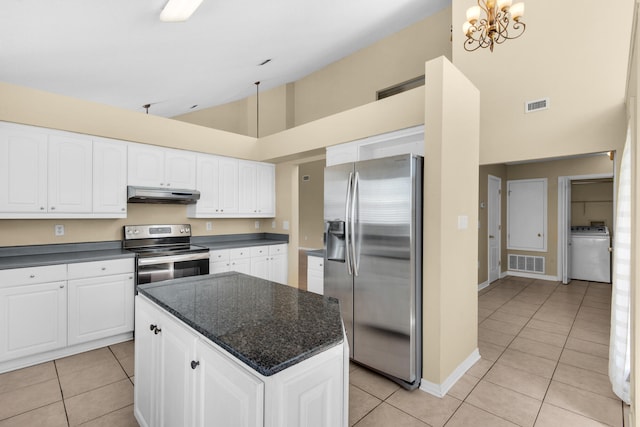 kitchen with high vaulted ceiling, washer / clothes dryer, white cabinetry, a center island, and stainless steel appliances