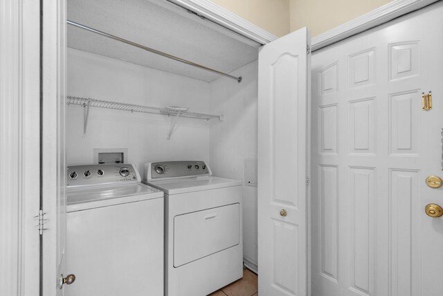 washroom with light tile patterned floors and washing machine and clothes dryer