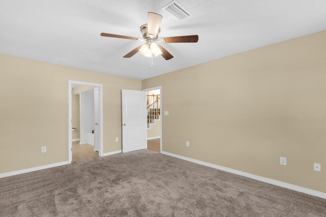 carpeted spare room featuring ceiling fan