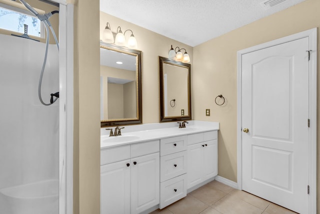 880 Brande Ct, Shalimar, FL 32579 - bathroom with double vanity, tile patterned floors, a textured ceiling, and baseboards