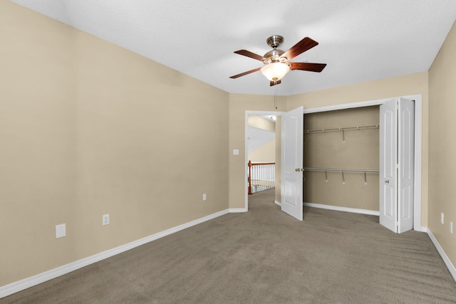 unfurnished bedroom with ceiling fan, carpet floors, a closet, and a textured ceiling