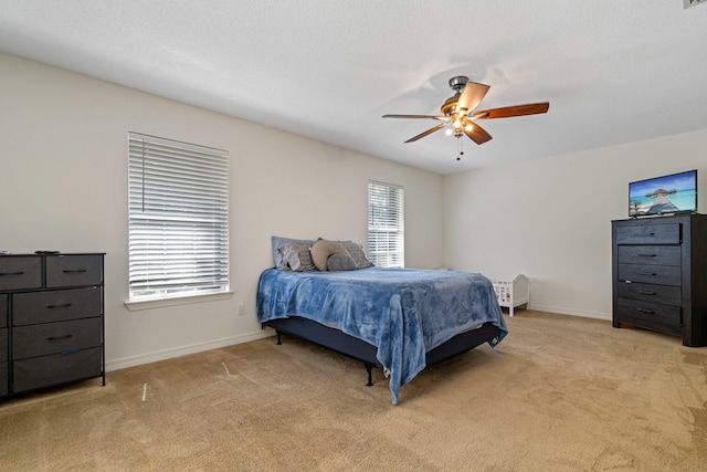 bedroom with light carpet, multiple windows, and ceiling fan