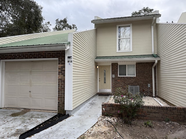 view of front of home with central AC and a garage