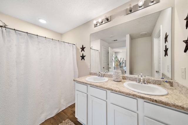 bathroom featuring a shower with curtain, vanity, hardwood / wood-style floors, and a textured ceiling