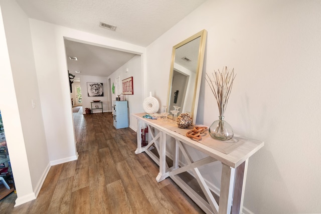 hallway with hardwood / wood-style floors and a textured ceiling