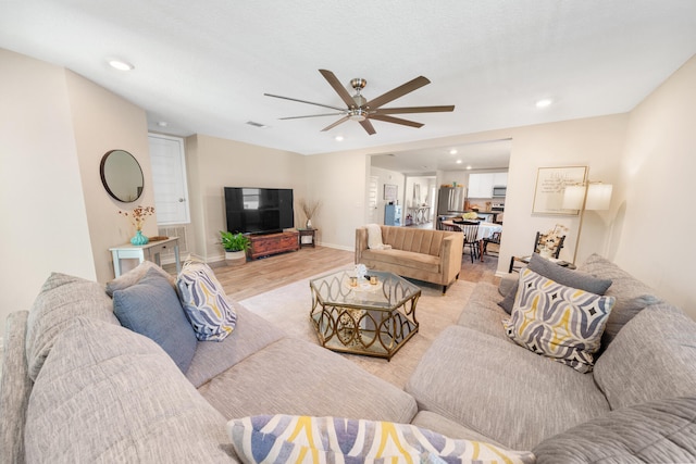 living room with light hardwood / wood-style flooring and ceiling fan