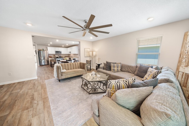 living room featuring light hardwood / wood-style floors and ceiling fan