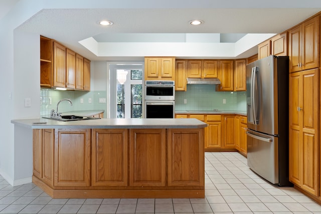 kitchen featuring stainless steel appliances, light tile patterned floors, sink, and kitchen peninsula