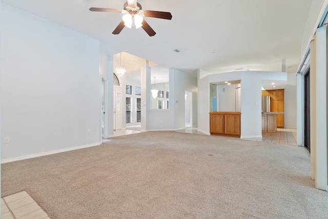 unfurnished living room featuring light colored carpet and ceiling fan with notable chandelier