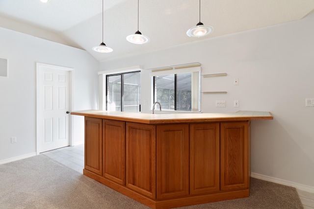 kitchen with kitchen peninsula, light carpet, pendant lighting, and lofted ceiling