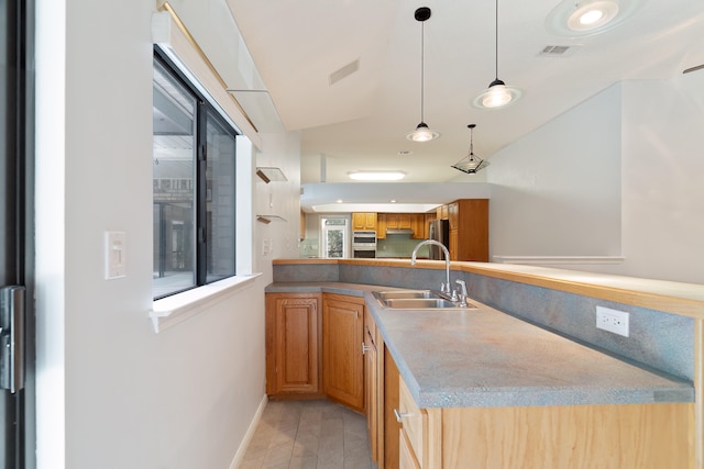 kitchen featuring kitchen peninsula, sink, and light hardwood / wood-style flooring