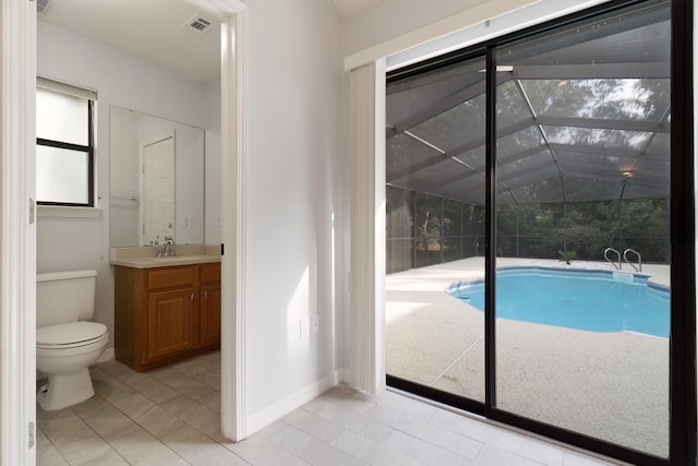 bathroom featuring toilet, lofted ceiling, vanity, and tile patterned floors