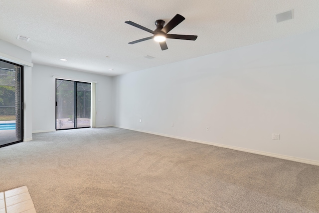 empty room with ceiling fan, a textured ceiling, and light colored carpet