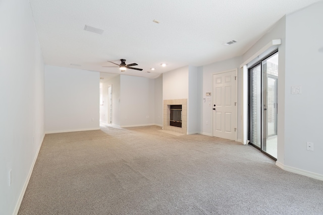 unfurnished living room featuring light colored carpet, ceiling fan, and a tile fireplace