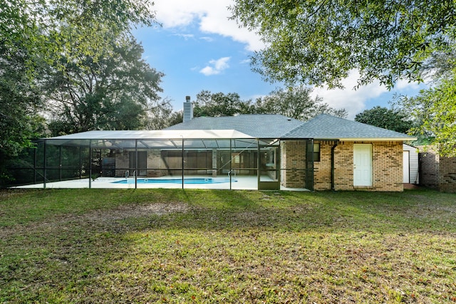 rear view of house featuring a lawn, a lanai, a fenced in pool, and a patio