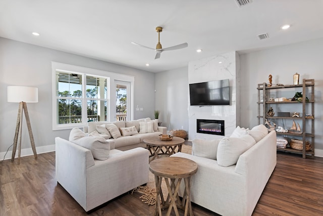 living room featuring dark hardwood / wood-style floors, a high end fireplace, and ceiling fan