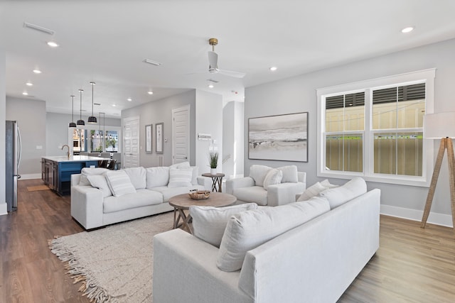 living room featuring ceiling fan, dark wood-type flooring, and sink