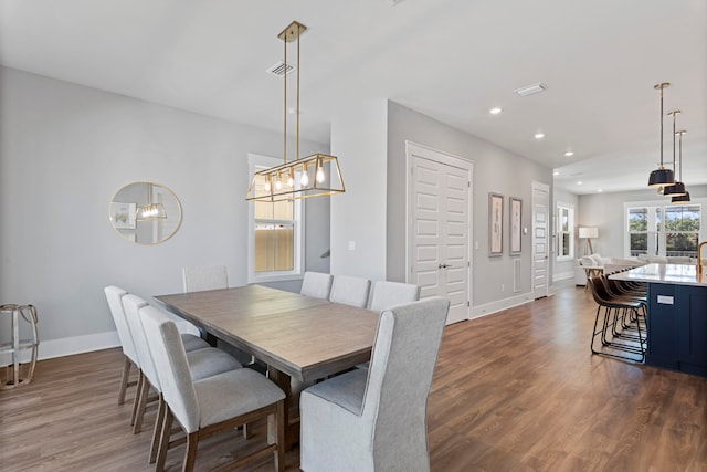 dining area featuring an inviting chandelier and dark wood-type flooring