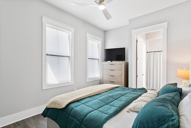 bedroom with ceiling fan, dark hardwood / wood-style floors, and multiple windows