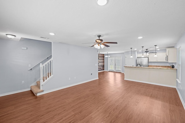 unfurnished living room featuring hardwood / wood-style floors and ceiling fan