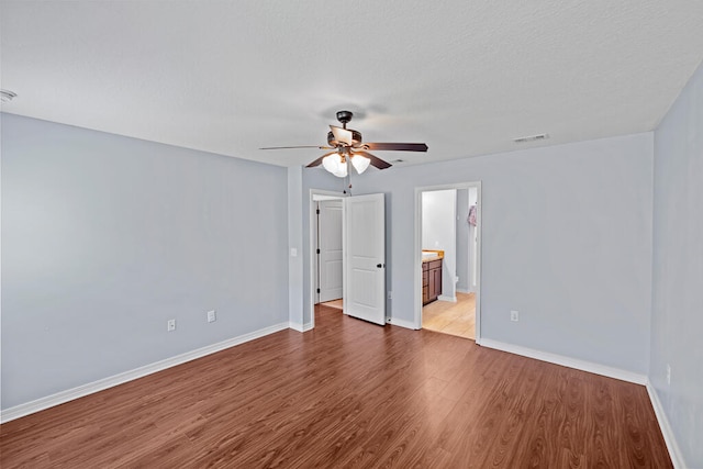 unfurnished room with ceiling fan, a textured ceiling, and light wood-type flooring