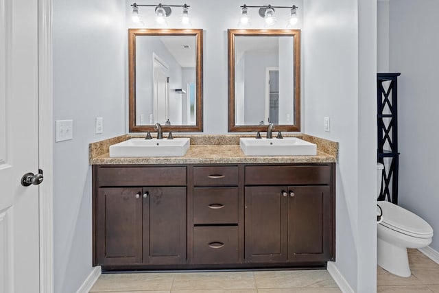 bathroom featuring toilet, vanity, and tile patterned flooring