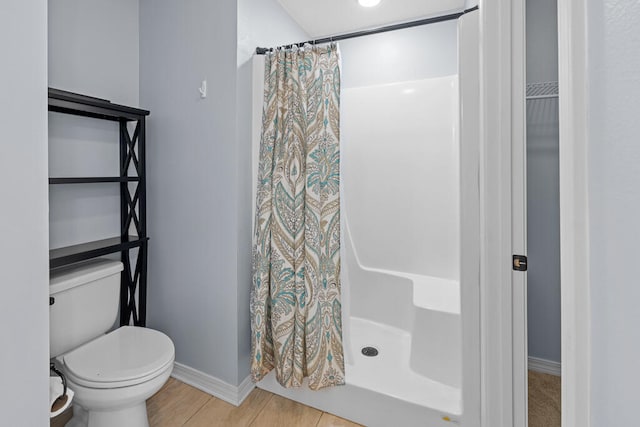 bathroom featuring wood-type flooring, a shower with curtain, and toilet