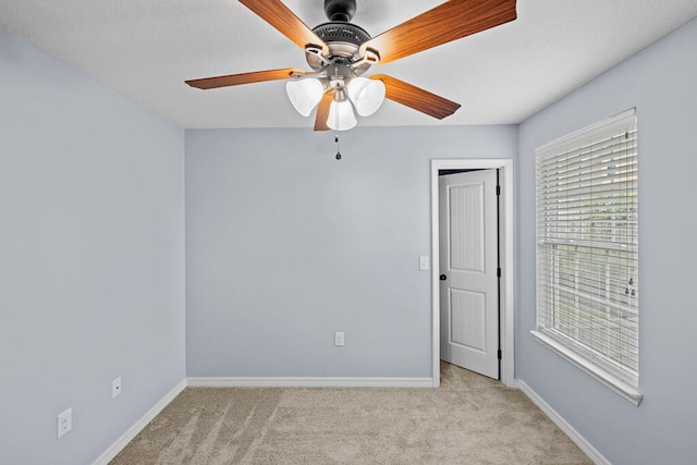 spare room featuring light carpet and ceiling fan