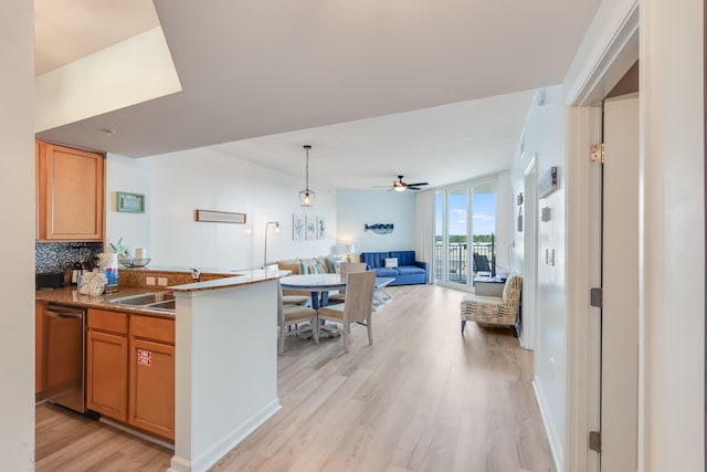 kitchen with light hardwood / wood-style floors, ceiling fan, sink, backsplash, and stainless steel dishwasher