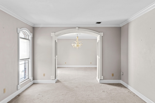 carpeted empty room featuring an inviting chandelier, a wealth of natural light, and crown molding