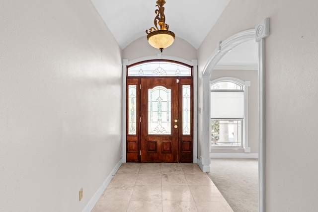 entrance foyer with crown molding, light carpet, and vaulted ceiling