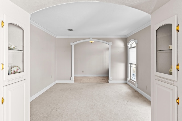 unfurnished room with light carpet, a textured ceiling, and crown molding