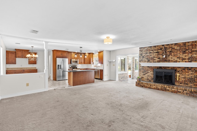 unfurnished living room with light carpet, a chandelier, and a brick fireplace