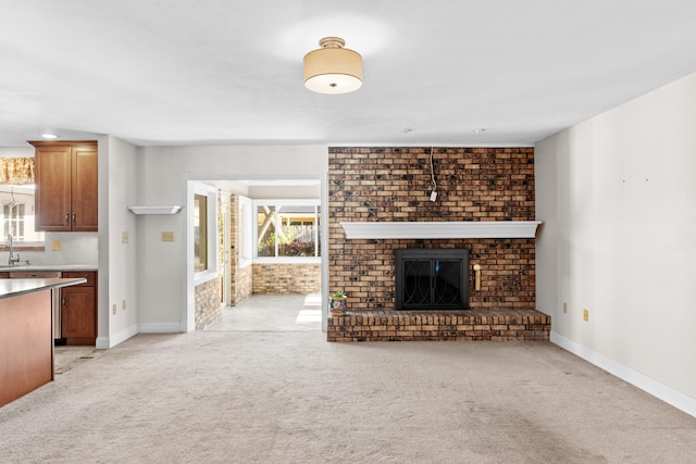 unfurnished living room featuring plenty of natural light, light colored carpet, a fireplace, and brick wall