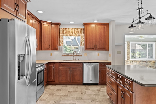 kitchen with a wealth of natural light, hanging light fixtures, sink, and appliances with stainless steel finishes