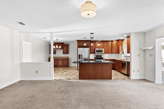 kitchen with light carpet, appliances with stainless steel finishes, sink, pendant lighting, and a center island