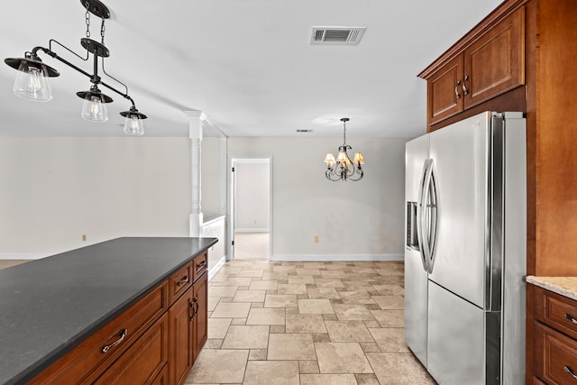 kitchen featuring stainless steel refrigerator with ice dispenser, hanging light fixtures, and a notable chandelier