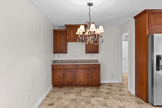 kitchen with a notable chandelier, stainless steel fridge with ice dispenser, and decorative light fixtures